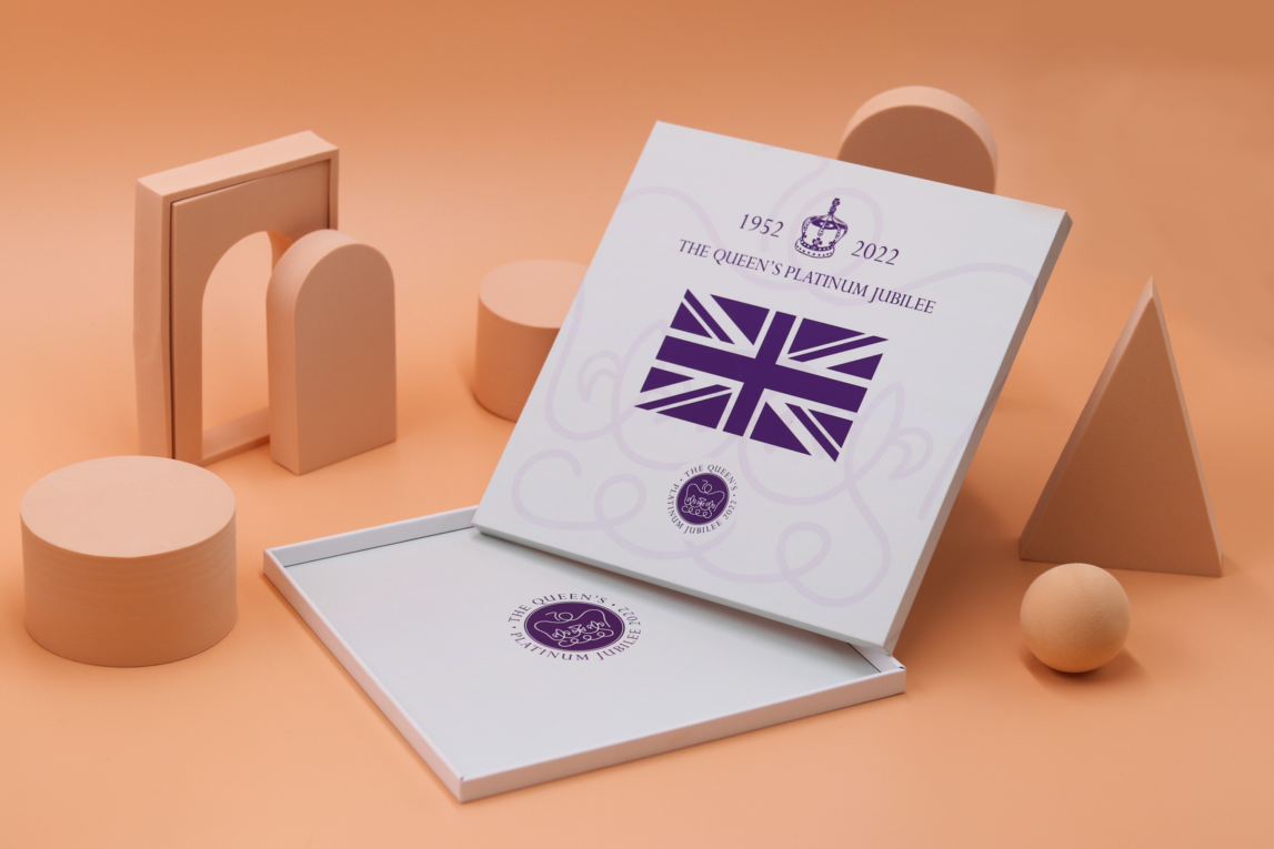 An open, empty square presentation box with a printed pattern commemorating the Platinum Jubilee