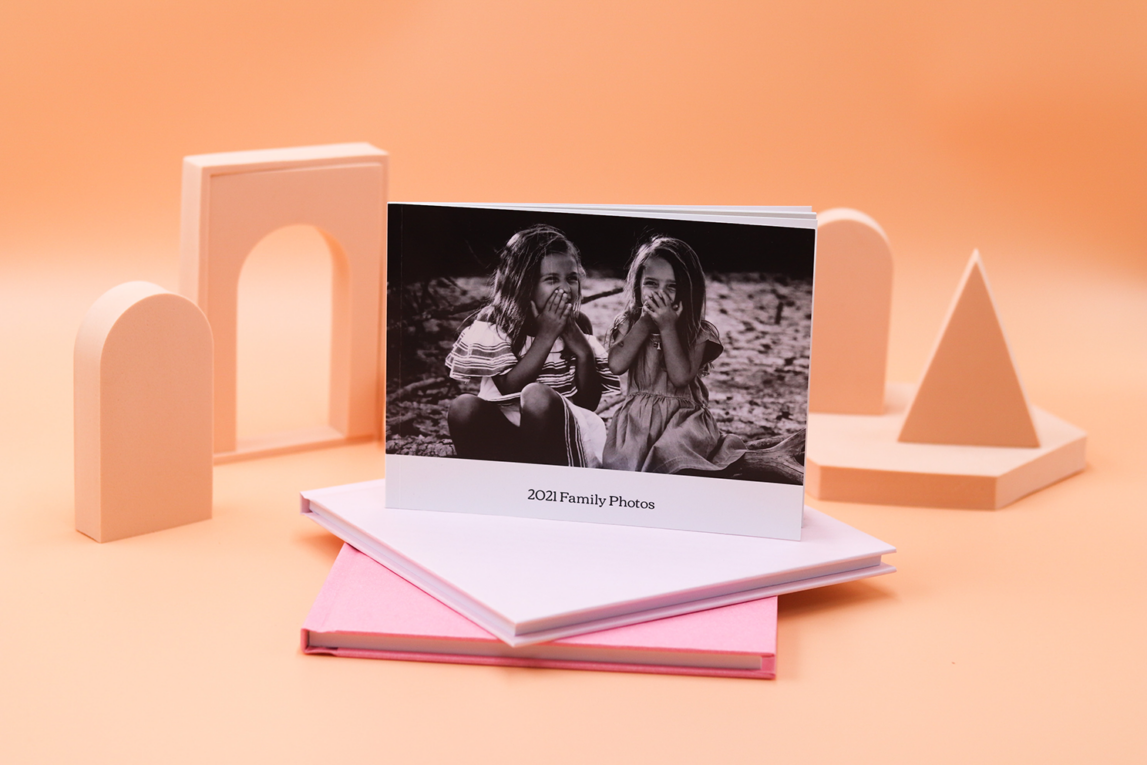 A '2021 Family Photos' photobook displayed on top of light pink photobooks.