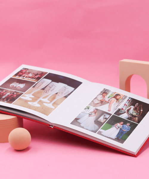 A Layflat photobook balanced on props with a pink background