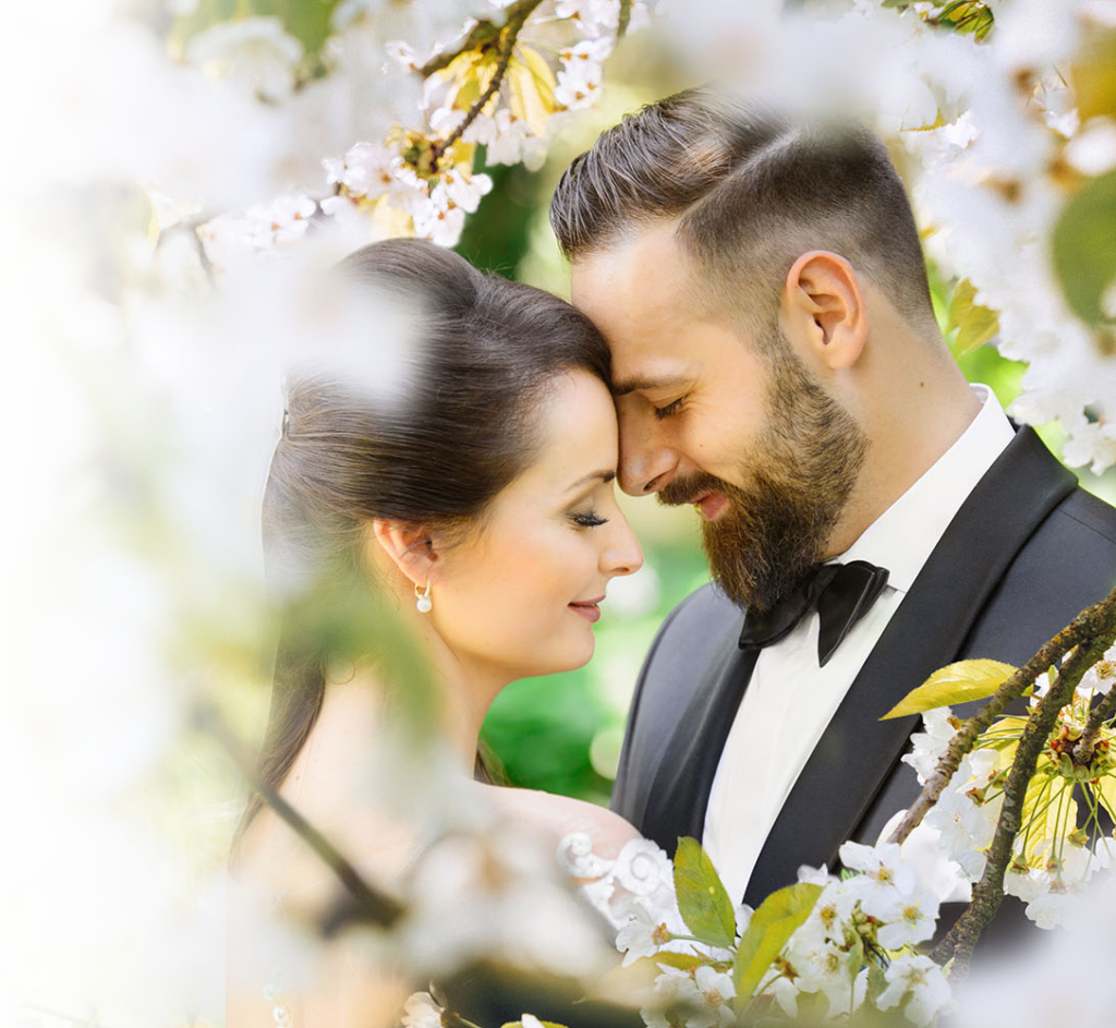 Fading image of bride and groom surrounded by plants